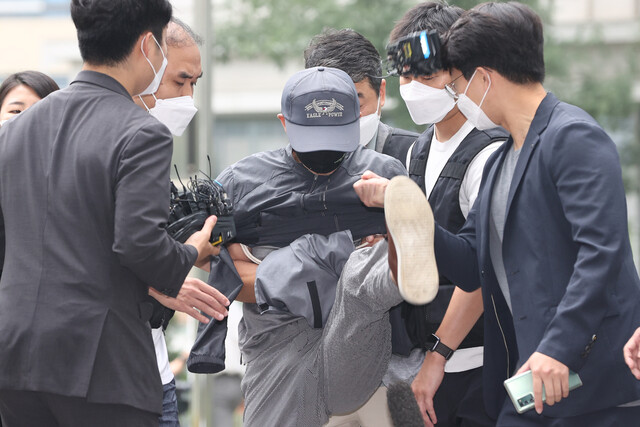 위치추적 전자장치(전자발찌) 훼손 전후로 여성 2명을 잇달아 살해한 혐의를 받는 강아무개씨가 31일 서울동부지법에서 열리는 영장실질심사에 출석하며 취재진의 마이크를 발로 차고 있다. 연합뉴스