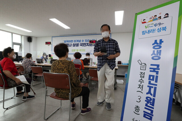 코로나 상생 국민지원금 현장 접수가 시작한 13일 오전 서울 성북구 길음1동 주민센터에서 한 주민이 코로나 상생 국민지원금 신청서 접수를 하고 있다. 김혜윤 기자 unique@hani.co.kr