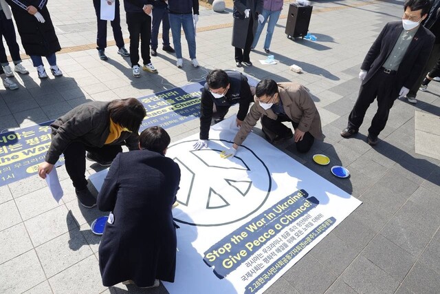 광주시민단체 회원들이 28일 오전 광주 동구 5·18민주광장에서 우크라이나 평화를 기원하는 평화 문양을 그리고 있다. 사회진보연대 광주전남지부 제공