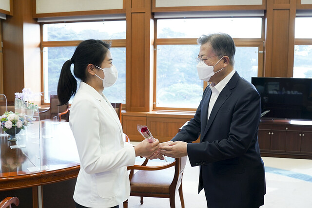 세계여성의 날인 8일 문재인 대통령이 청와대 집무실에서 김현지 간호장교에게 \"세계여성의 날을 축하하며 당신을 응원합니다\"라는 메시지가 담긴 장미꽃과 함께 격려의 말을 전하고 있다. 청와대 제공