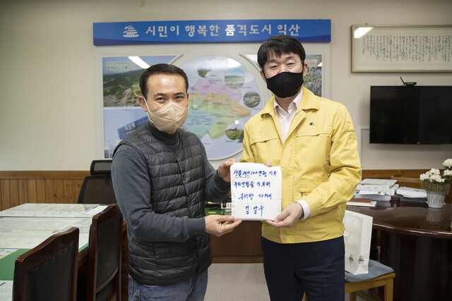 전북 익산의 ‘붕어빵 아저씨’ 김남수(왼쪽)씨가 15일 익산시청을 방문해 산불 피해자를 위한 성금 100만원을 오택림 부시장에게 전달했다. 익산시 제공