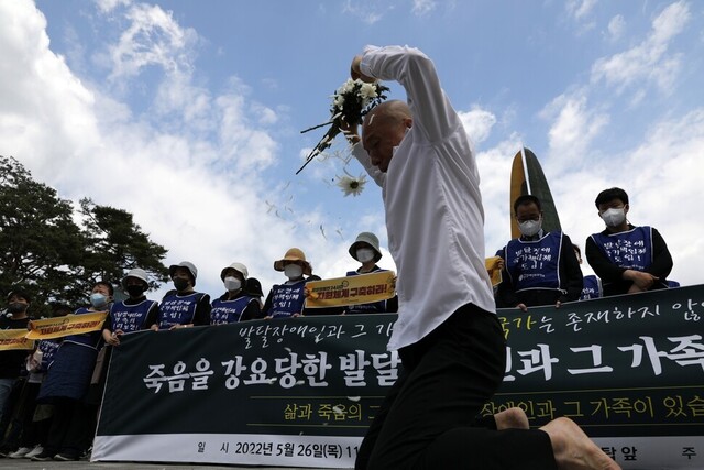 2022년 5월 26일 오전 서울 용산구 대통령집무실 앞에서 열린 전국장애부모연대 주관 '죽음을 강요당한 발달장애인과 그 가족에 대한 추모제'에서 참가자가 국화를 들고 있다.류우종 기자 wjryu@hani.co.kr