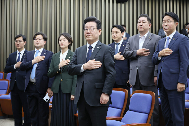 이재명 더불어민주당 대표가 25일 오후 국회에서 열린 의원총회에서 국기에 경례하고 있다. 연합뉴스