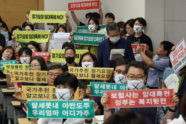 지난달 19일 서울 중구 대한상공회의소에서 열린 ‘신노년층을 위한 요양시설 서비스 활성화 방안 연구 관련 공청회’에서 민주노총 전국돌봄서비스노조, 보건의료노조 등 관계자들이 장기요양시설 임대 허용 추진을 반대하는 손팻말을 들고 있다. 연합뉴스