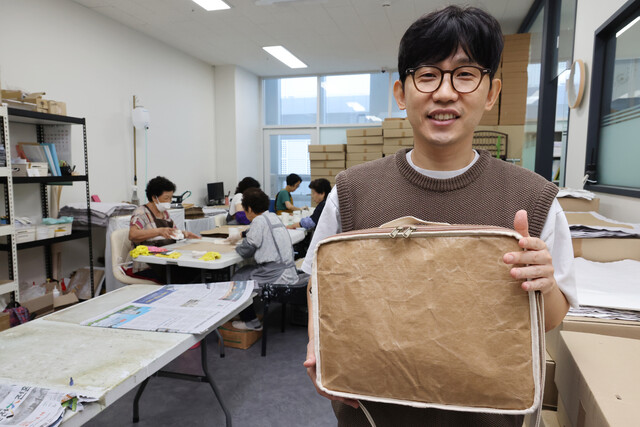 기우진 러블리페이퍼 대표가 종이가죽으로 만든 노트북 가방을 들어 보이고 있다.