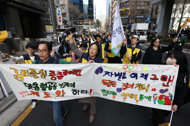 지난 3월 서울 중구 서울시청 인근 도로에서 열린 지속 가능한 권리중심 중증장애인 맞춤형 공공일자리를 위한 결의대회를 마친 참가자들이 행진하고 있다. 연합뉴스