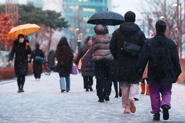 19일 오후, 서울을 비롯한 중부지방에 눈이 내려 서울 강남구 삼성역 일대를 지나는 시민들이 발걸음을 재촉하고 있다. 연합뉴스