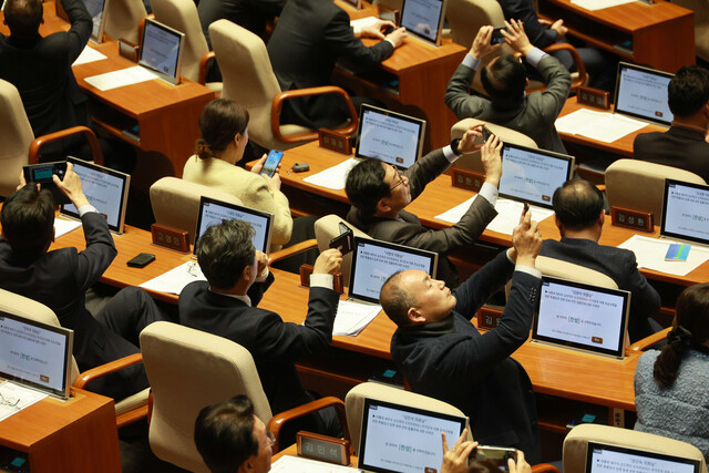 28일 국회 본회의에서 야당 의원들이 대통령 배우자 김건희의 도이치모터스 주가조작 의혹 진상규명을 위한 특별검사 임명 등에 관한 법률안 표결 모습을 촬영하고 있다. 연합뉴스