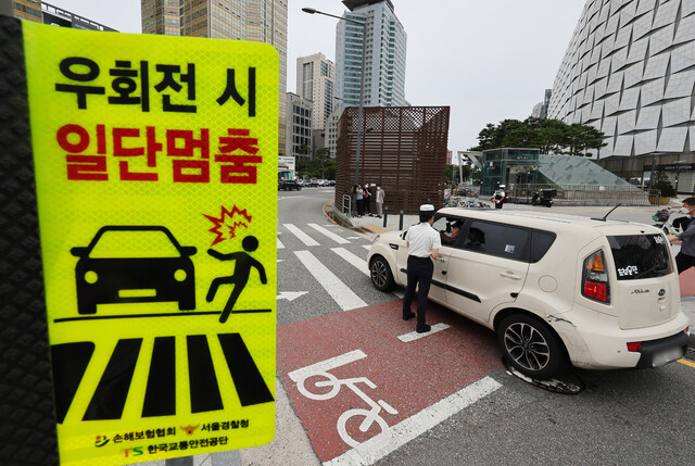 '횡단보도 보행자 보호'를 골자로 하는 개정 도로교통법 시행 첫날인 12일 서울 송파구 잠실역 교차로에서 송파경찰서 경찰관들이 계도 활동을 하고 있다. 연합뉴스