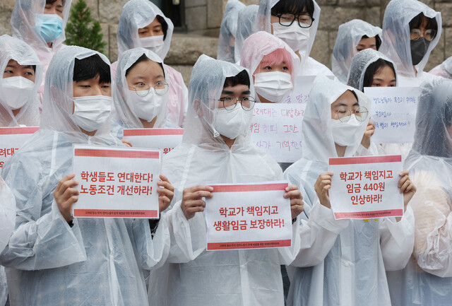 13일 서울 성북구 고려대학교 본관 앞에서 열린 고려대 청소·주차·경비노동자 문제해결을 촉구하는 학생 기자회견에서 학생과 노동자들이 손팻말을 들고 있다. 연합뉴스