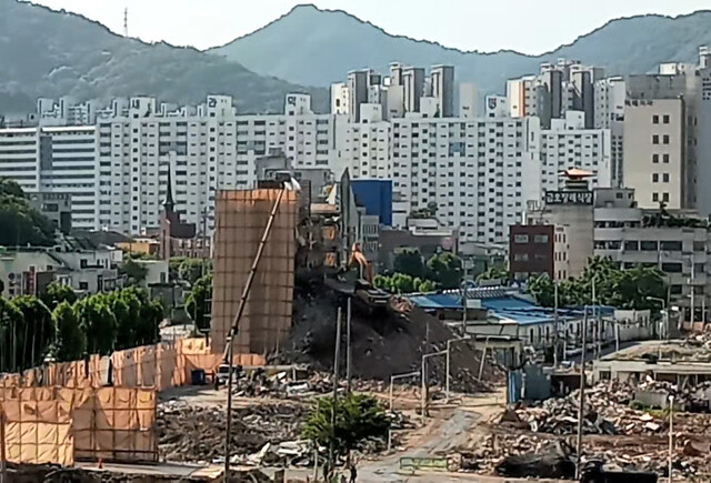 광주광역시 동구 학동 4구역 재개발 사업지에서 지난 9일 오전 굴착기가 건물 뒤편에 약 45도 경사로 쌓아 올린 흙더미 위에 올라 철거하고 있다. 연합뉴스