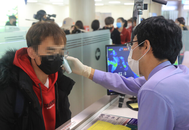 23일 오전 제주국제공항 국제선 입국장에서 질병관리본부 국립제주검역소 직원이 고막 체온계를 이용해 열이 있는 중국 난징발 입국자의 체온 측정을 하고 있다. 연합뉴스