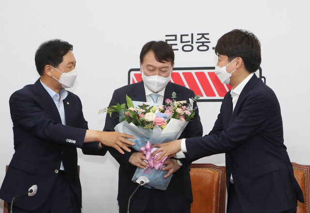 윤석열 전 검찰총장이 2일 오전 국회에서 김기현 원내대표(왼쪽)와 이준석 당 대표(오른쪽)에게 환영의 꽃다발을 받고 있다. 공동취재사진