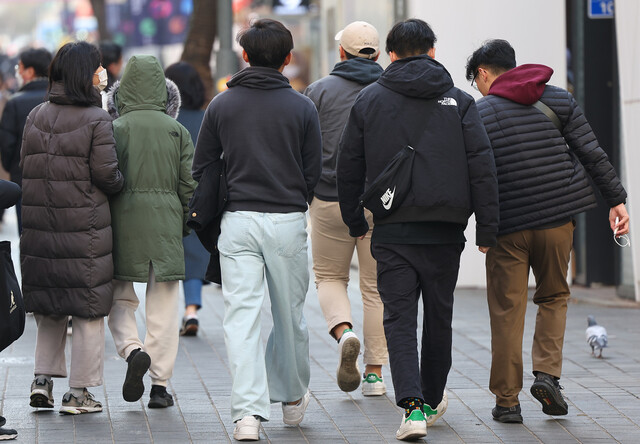 전국 대부분 지역이 평년기온 보다 3~5도 정도 높은 기온을 보인 지난 10일 오후 서울 명동에서 한 시민이 외투를 벗어들고 길을 지나고 있다. 연합뉴스