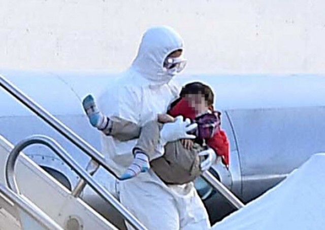 신종 코로나바이러스 감염증 발원지인 중국 후베이성 우한과 인근 지역에서 철수한 교민을 태운 전세기가 31일 오전 김포국제공항에 도착, 한 교민 어린이가 관계자의 품에 안겨 대한항공 전세기에서 내리고 있다. 연합뉴스