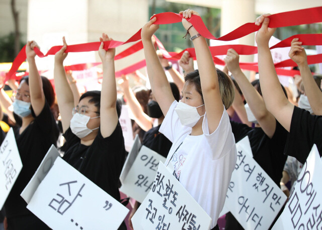 텔레그램 성착취 `박사방' 관련 첫 재판이 열린 지난 6월11일 낮 서울 서초구 서울중앙지법 앞에서 텔레그램 성착취 공동대책위원회 주최로 열린 기자회견 `우리의 연대가 너희의 공모를 이긴다'에서 참석자들이 함께 연대를 한다는 의미로 끈을 잇는 행위극을 하고 있다. 백소아 기자 thanks@hani.co.kr