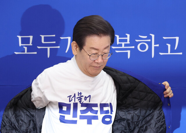 24일 국회에서 열린 더불어민주당 새 PI 선포식에서 이재명 대표가 새 로고가 프린트 된 옷으로 환복하고 있다. 연합뉴스