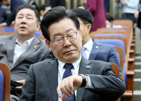 이재명 더불어민주당 대표가 지난 25일 오후 국회에서 열린 의원총회에서 시간을 확인하고 있다. 연합뉴스