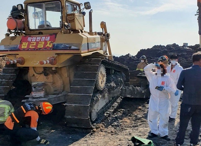 5일 오전 전남 여수시 묘도동 매립장에서 60대 노동자가 불도저에 깔려 소방대원들이 사고 현장을 점검하고 있다.여수소방서 제공