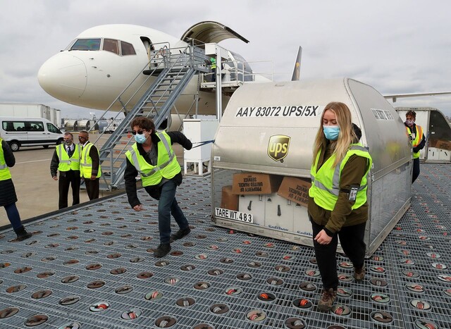 13일 미국 켄터키주 루이스빌의 공항에서 배송업체 노동자들이 화이자가 개발한 코로나19 백신을 옮기고 있다. 루이스빌/로이터 연합뉴스