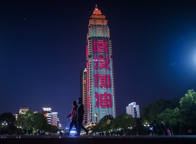 코로나19의 진원지인 중국 후베이성 우한에서 76일간의 삼엄한 봉쇄가 해제된 뒤 12일 시민들이 마스크를 낀 채 산책을 하고 있다. 우한/신화 연합뉴스