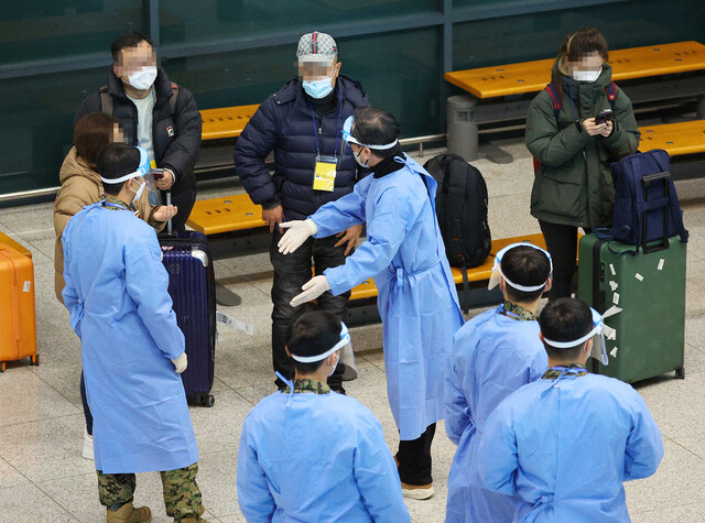 3일 인천국제공항 제1여객터미널에서 방역 요원들이 중국발 입국자들에게 코로나19 진단검사 등을 안내하고 있다. 연합뉴스