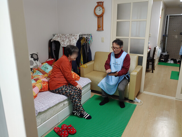 서울시 사회서비스원 은평종합재가센터 구인수 요양보호사가 방문요양을 받는 어르신에게 휴대전화 사용법을 알려주고 있다. 거주공간 위생 환경을 개선하기 위해 남자 요양보호사를 포함한 3명이 함께 대청소를 했다. 서울시 사회서비스원 제공