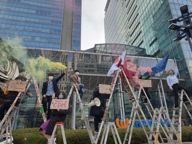 서울 강남구 포스코센터 앞에서 시민단체들이 사다리 위에 올라가 연막탄을 터뜨리며 “포스코는 반성하고 미얀마에 사과하라”고 구호를 외치고 있다. 전광준 기자.