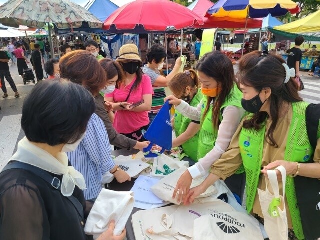 지난 10일 광주 금요상무시장에서 장을 보러 나온 시민들이 무료 에코백을 고르고 있다. 광주도시공사 제공