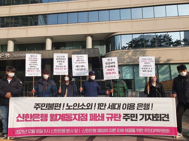 16일 오전 서울 중구 신한은행 본사 앞에서 열린 ‘신한은행 월계동지점 폐쇄 규탄 주민 기자회견’에 참석한 ‘신한은행 폐점에 따른 피해 해결을 위한 주민대책위원회’ 관계자들이 손팻말을 들고 있다. 장현은 기자 mix@hani.co.kr