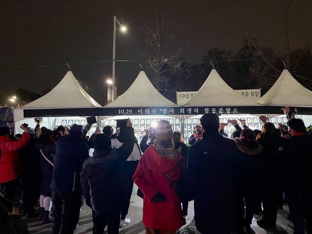 1일 서울 용산구 이태원 광장에 차려진 시민분향소에 모인 이태원 참사 유가족 50여명이 0시에 맞춰 희생자들의 이름이 띄운 휴대전화를 하늘로 들어 올린 채 희생자들의 이름을 부르고 있다. 10·29 이태원 참사 시민대책회의 제공