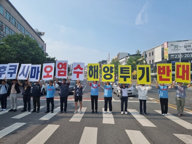 전북환경운동연합 등 전북지역 시민·사회단체 회원들이 보호자 신호등이 파란불일 때 횡단보도에서 손팻말을 들고 오염수 투기 반대를 외치고 있다. 전북환경운동연합 제공