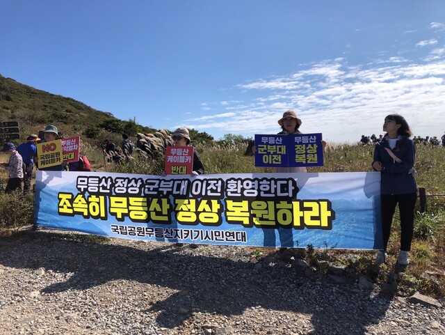 광주환경단체 회원들이 무등산 정상 개방 행사가 열린 지난 8일 무등산 정상 군부대 이전을 촉구하는 홍보활동을 하고 있다. 광주환경운동연합 제공