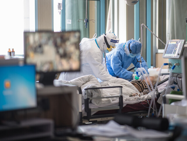 중국 후베이성 우한의 병원 중환자실에서 22일 방호복을 입은 의료진이 코로나19 환자를 돌보고 있다. 신화 연합뉴스