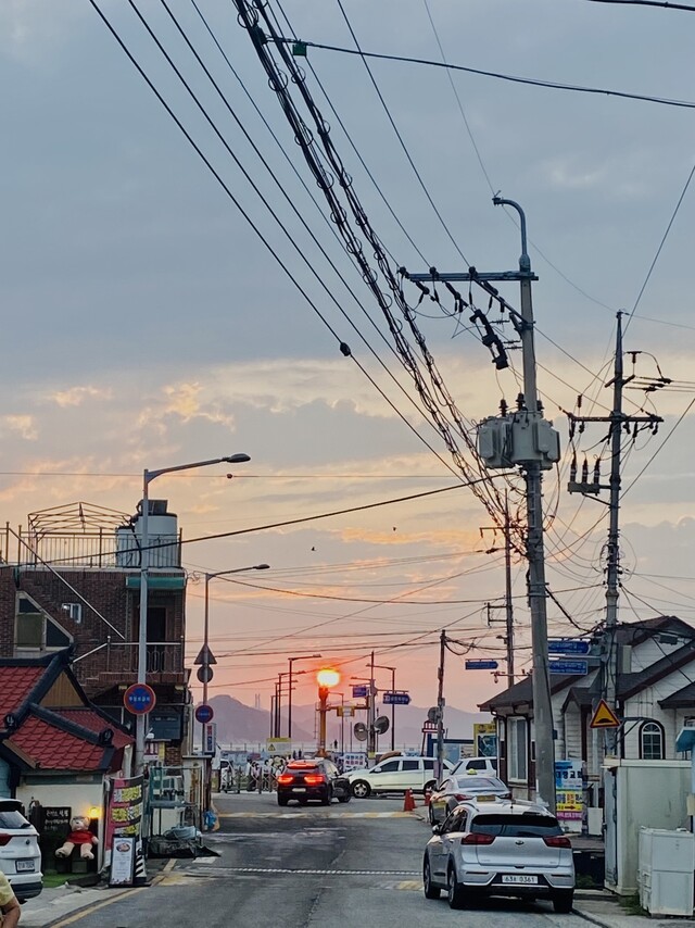 복잡한 전깃줄 아래 길을 걷다가 일몰을 만났다. 김비 제공