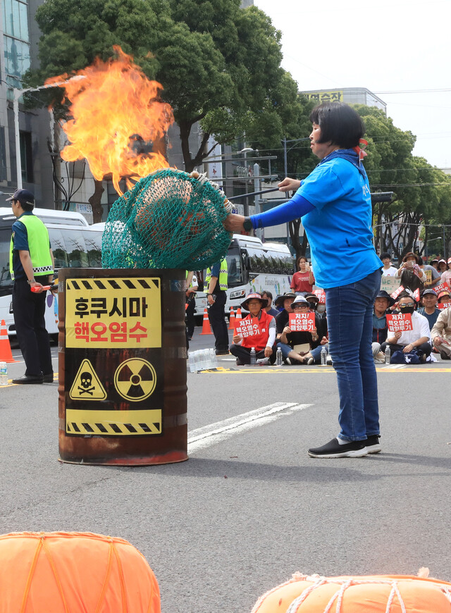 6월13일 오후 제주시 노형오거리에서 열린 ‘일본 핵오염수 해양투기 저지 제주 범도민대회'에서 제주도해녀협회 고송자 사무국장이 항의 표시로 테왁(해녀 물질 기구)을 태우고 있다. 연합뉴스