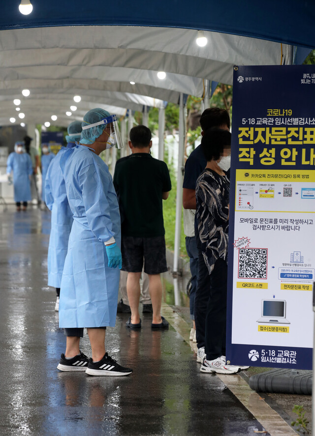 11일 오후 광주 서구 5·18민주화운동 교육관에 재설치 운영에 들어간 임시선별검사소에서 의료진이 코로나19 검사를 받으려는 시민들의 문진표 작성을 돕고 있다. 연합뉴스.