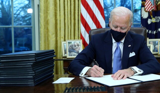 20일(현지시각) 취임식과 함께 대통령 업무를 시작한 조 바이든 미국 대통령이 워싱턴 백악관 집무실에서 행정명령에 서명하고 있다. 워싱턴/로이터 연합뉴스