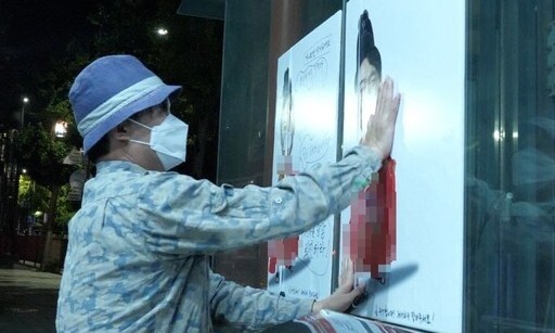 지난 13일 서울 용산 대통령실 주변에 윤석열 대통령을 벌거벗은 임금님으로 표현한 포스터를 붙이고 있는 이하씨. 이하씨 페이스북 갈무리