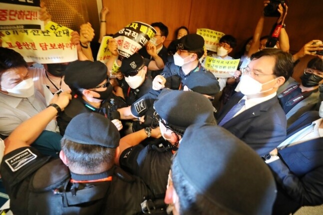 22일 인천국제공항 제1여객터미널에서 보안검색 노동자 정규직화 관련 브리핑을 마친 구본환 인천국제공항공사 사장이 브리핑실을 나와 엘리베이터로 이동하던 중 직원들의 거센 항의를 받고 있다. 연합뉴스