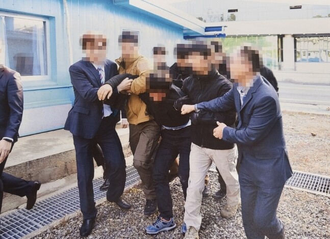 통일부는 2019년 11월 판문점에서 탈북어민 2명을 북한으로 송환하던 당시 촬영한 사진을 12일 공개했다. 당시 정부는 북한 선원 2명이 동료 16명을 살해하고 탈북했으나 귀순 의사에 진정성이 없다고 보고 판문점을 통해 북한으로 추방했다. 이들이 북송에 반발하는 모습. 통일부 제공