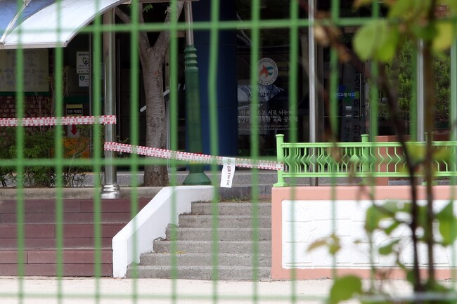 코로나19 집단감염이 발생한 광주 광산구 수완지구 성덕고등학교 교정에 11일 출입 금지를 알리는 빨간 테이프가 둘러졌다. 연합뉴스