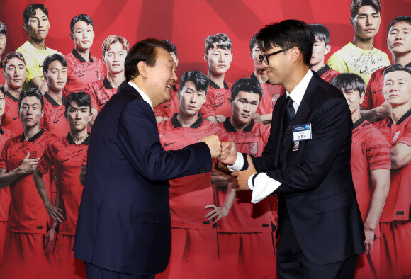 8일 청와대 영빈관에서 열린 축구 국가대표팀 환영 만찬에서 윤석열 대통령이 주장 손흥민 선수로부터 2022 카타르 월드컵 기간 착용했던 주장 완장을 선물받은 뒤 주먹을 맞대고 있다. 연합뉴스