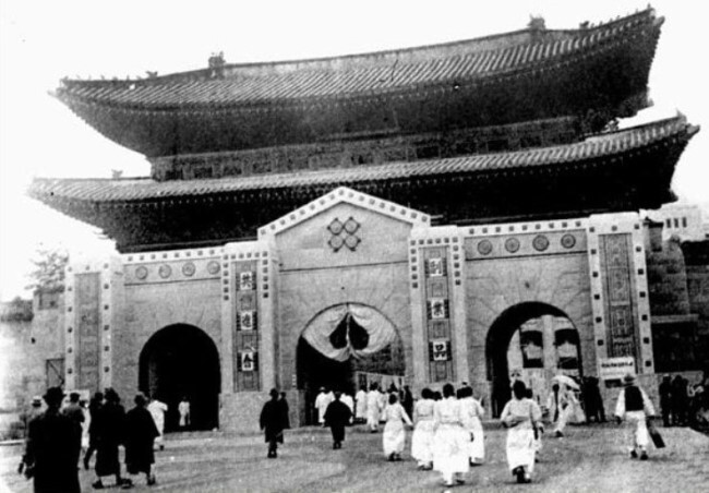 1915년 조선물산공진회가 열릴 당시 출입문으로 쓰인 광화문의 모습. 문 앞에 일장기와 일왕가의 국화 문양 등으로 꾸며진 가설 장식문이 덧대졌다.