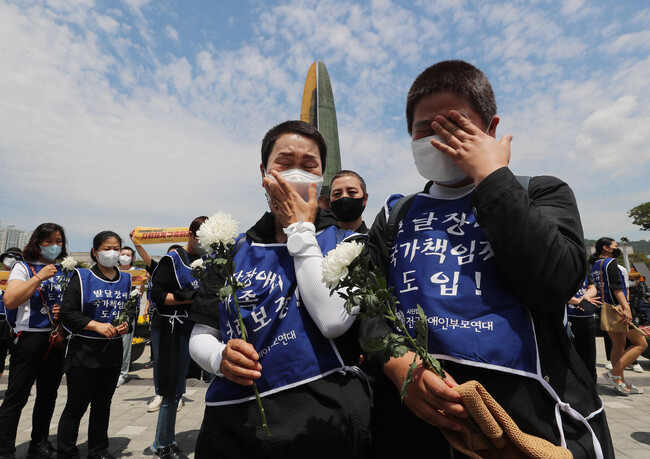 전국장애인부모연대 회원들이 26일 오전 서울 용산구 대통령 집무실 앞에서 열린 ‘죽음을 강요당한 발달장애인과 그 가족에 대한 추모제’에서 참석자들이 최근 함께 죽음을 선택한 발달장애인 가족 분향소 앞에서 눈물을 흘리며 헌화하고 있다. 이들은 정부에 24시간 지원체계구축 등을 촉구했다. 신소영 기자 viator@hani.co.kr