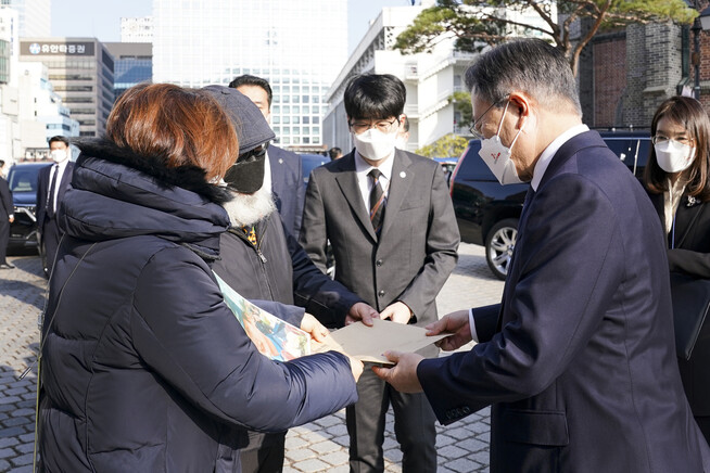문재인 대통령이 25일 서울 중구 명동성당 꼬스트홀에서 열린 국가인권위원회 설립 20주년 기념식에 참석한 뒤 이예람 공군 중사의 아버지로부터 면담요청서 및 입장문을 전달받고 있다. 청와대 제공