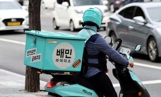 서울의 한 거리에서 배민라이더스 노동자가 배달에 나서고 있다. 연합뉴스