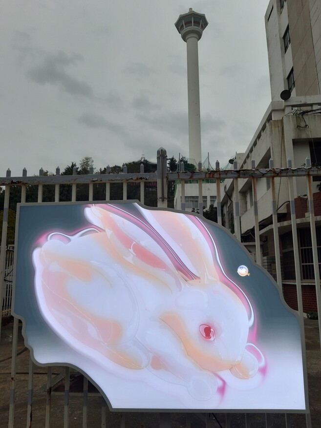부산 용두산공원의 부산타워를 배경으로 옛 한국은행 부산본부 담장에 설치된 람한 작가의 라이트패널 작품. 중앙동과 남포동 등 부산 원도심 야외 설치작업의 일부다.