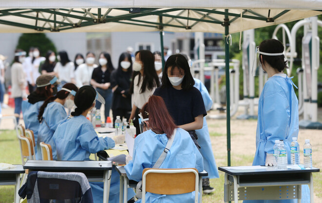 지난 6일 인천시 연수구 인천뷰티예술고 운동장에 설치된 선별 진료소에서 학생들이 검체 검사를 받기 전 줄을 서고 있다. 연합뉴스