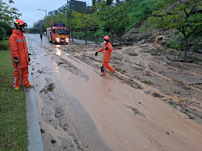 14일 오전 5시30분께 경기 오산시 지곶동 한 도로에 토사가 흘러내려 소방당국이 안전조처를 하고 있다. 경기도소방재난본부 제공